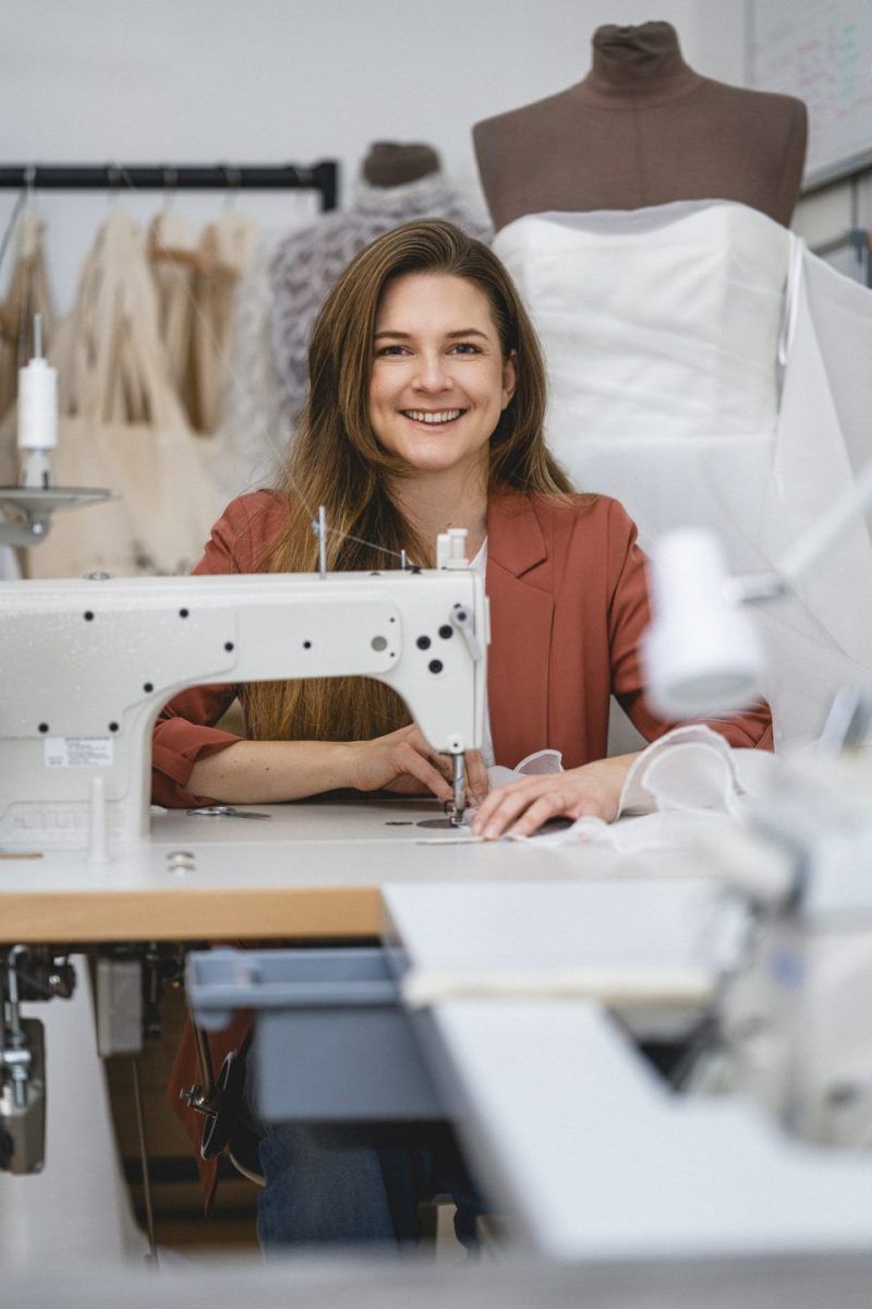 Junge Designerin arbeitet im Atelier Victoria Rüsche an einem maßgeschneiderten Brautkleid aus edlem Stoff
